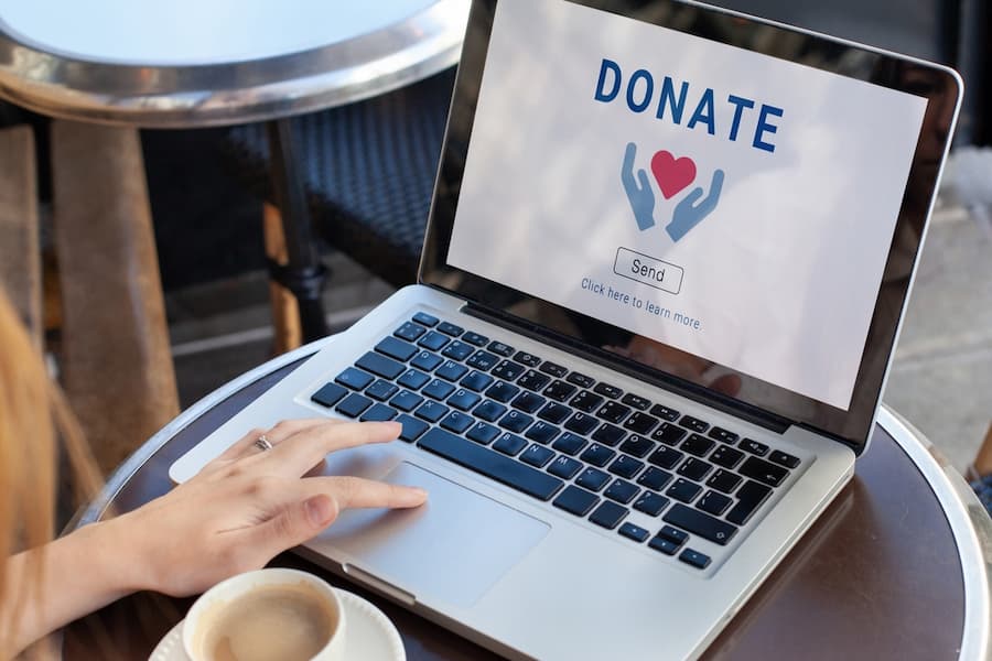 An open laptop with the word 'donate' on the screen