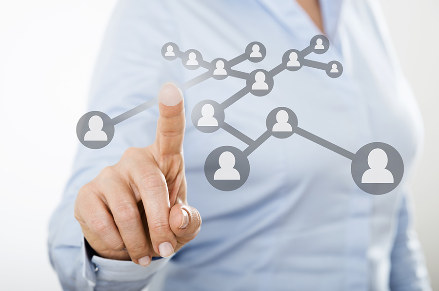A woman points to an overlaid graphic of linked basic head and shoulders shapes