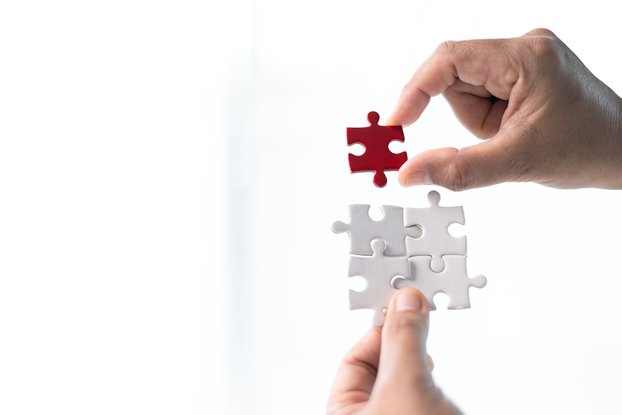 A red jigsaw piece slots into four white pieces