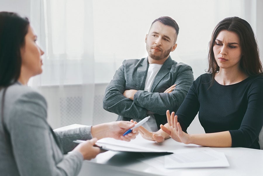 A couple look annoyed while having a discussion with a solicitor