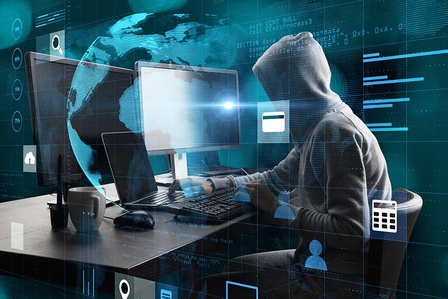 A hacker at a desk surrounded by screens, with graphics of credit cards overlaid