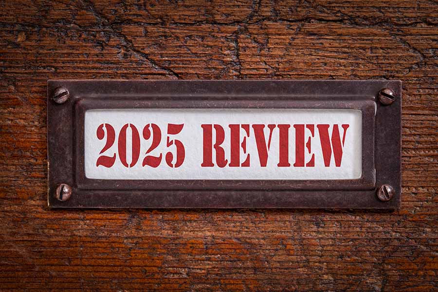 A close-up of an old-fashioned wooden filing cabinet with a typed label saying '2025 in review'