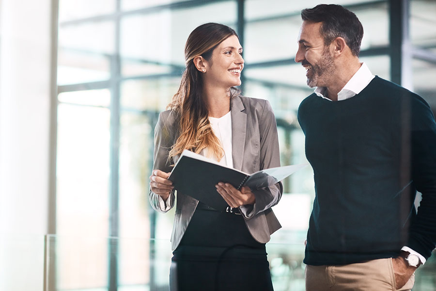 A smiling couple in an office holding a file
