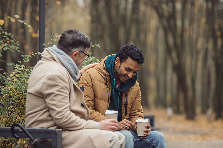 Two men talking on a bench