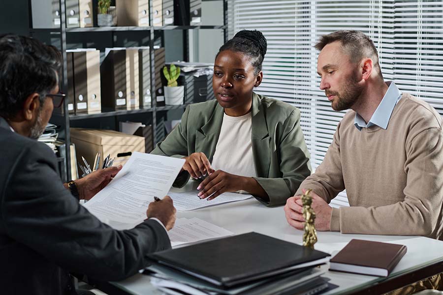 A professional at a desk talking to a couple