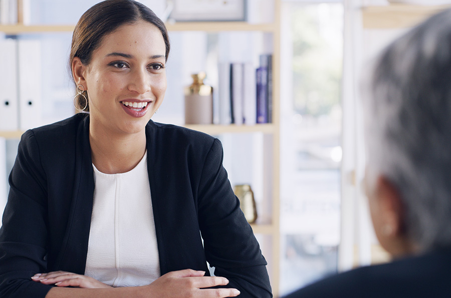 A friendly adviser speaking to an older person in an office setting
