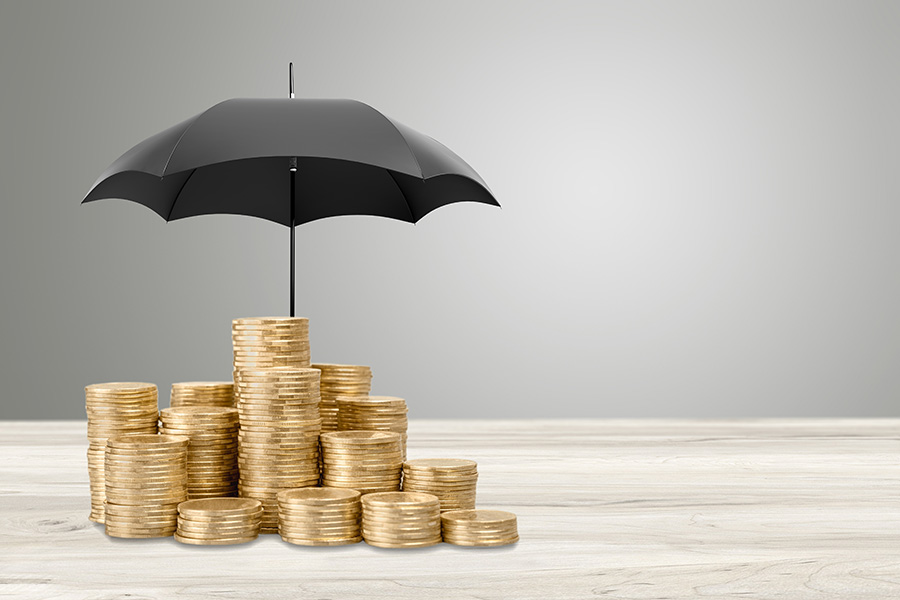 An umbrella over a pile of gold coins