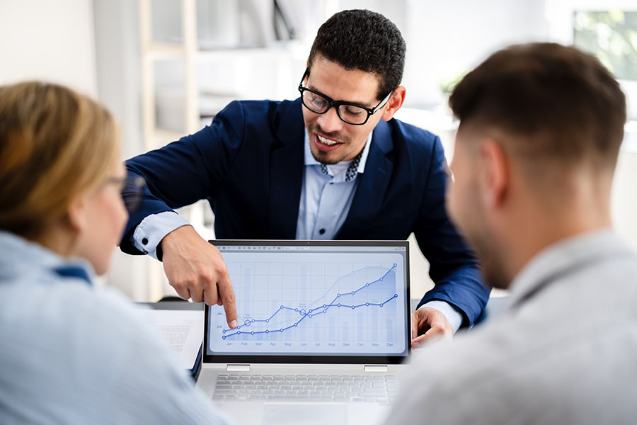 A financial adviser shows a graph to a young couple