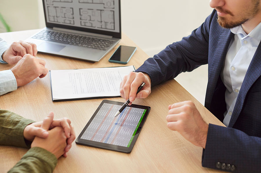 A financial adviser explaining rows of figures to two clients