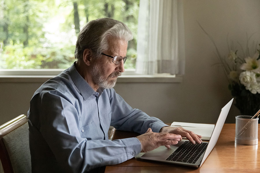 An older man using a laptop