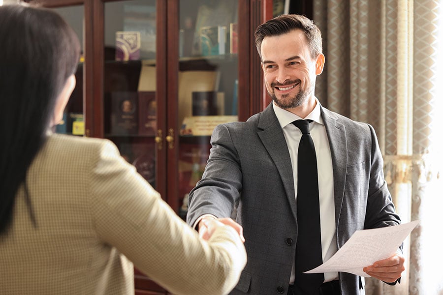 Smiling lawyer shaking hands with client in an office