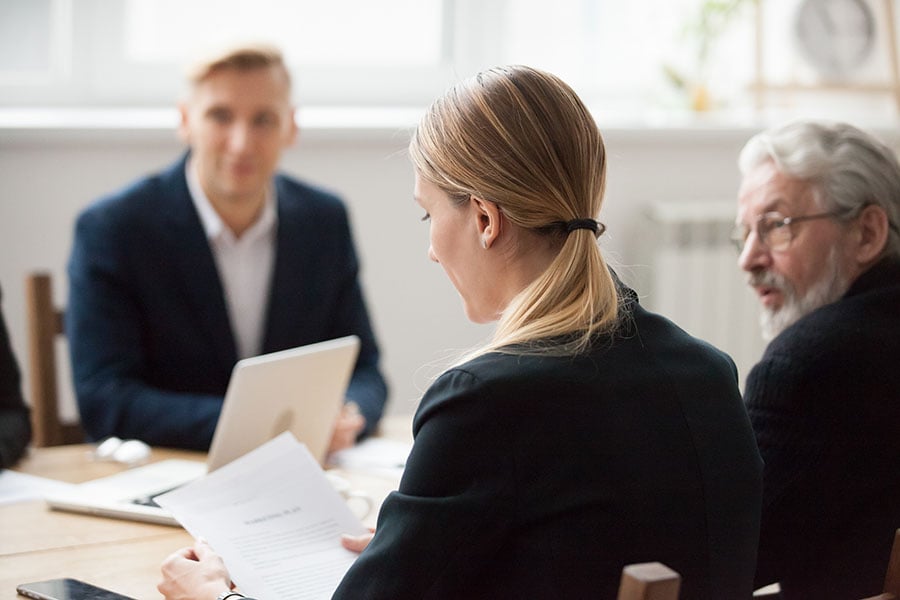 A group of solicitors around a table discussing papers in front of them