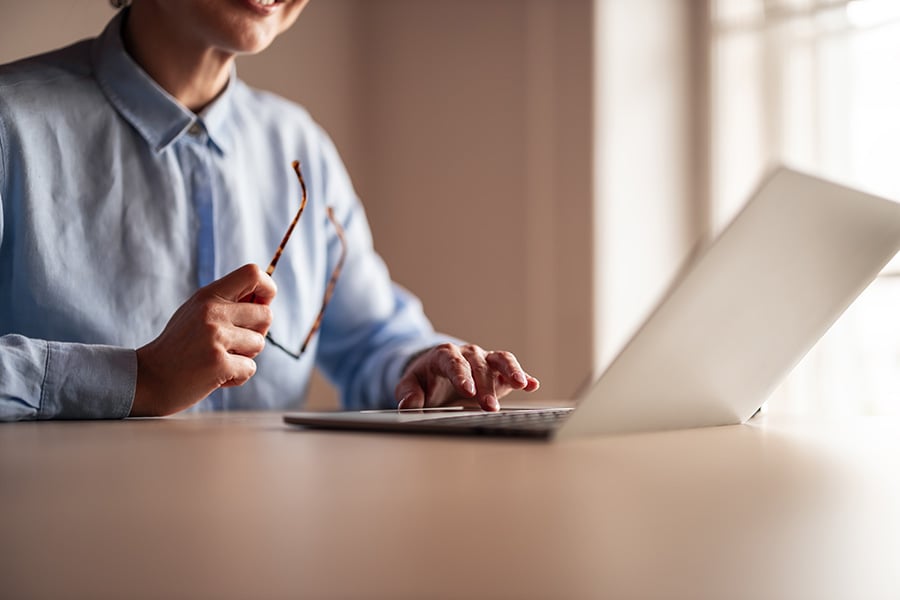 A smiling woman using a laptop