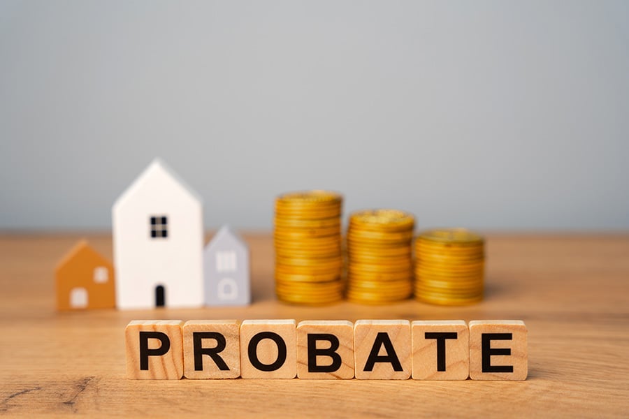 The word probate spelled on on blocks, in front of a small house and piles of coins