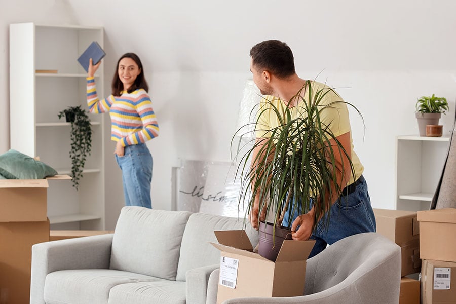 A couple move boxes into a rented flat