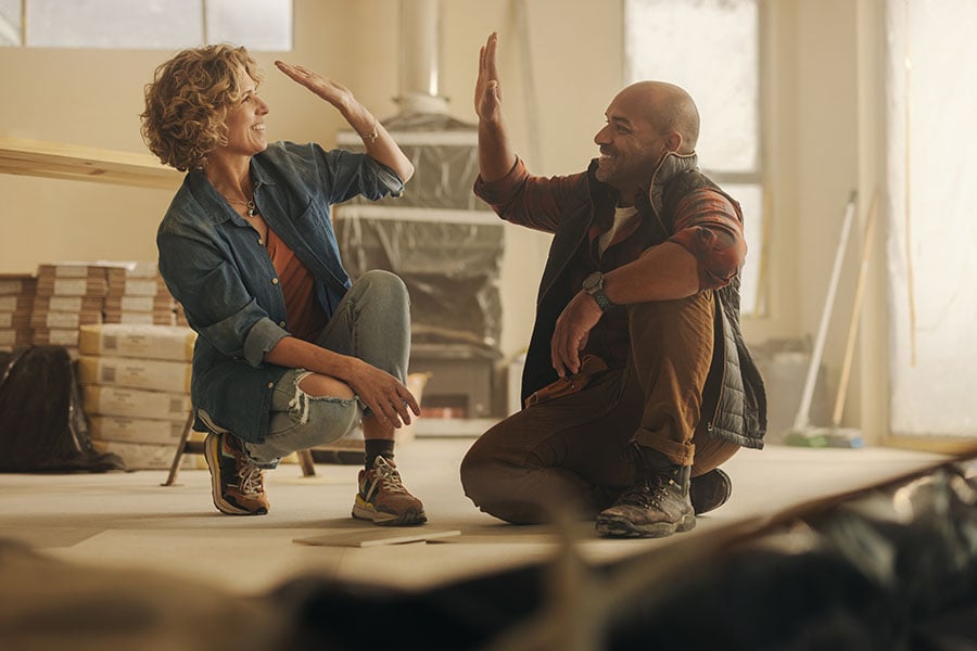 A couple high five each other surrounded by DIY equipment