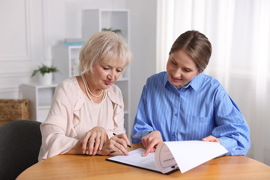 A financial adviser and her client sign a document