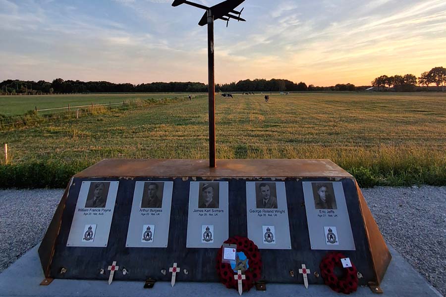 A memorial to pilots in a field at sunset