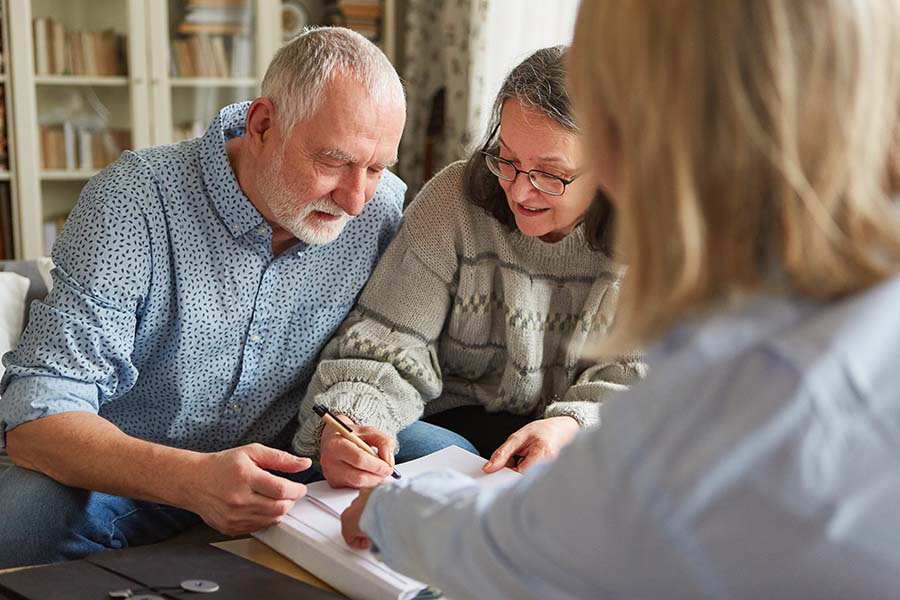 An older couple signing a will in the presence of a notary