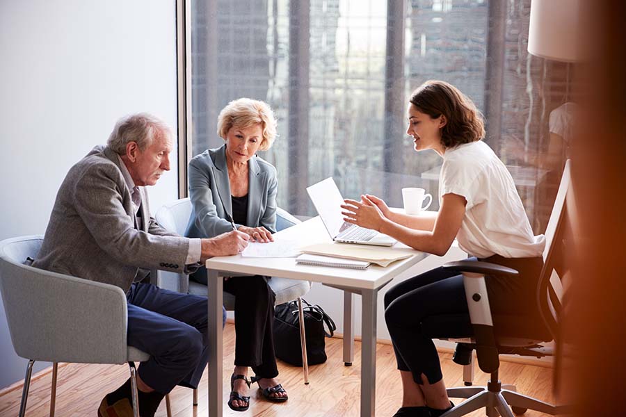 businesswoman with old couple explaining paperwork