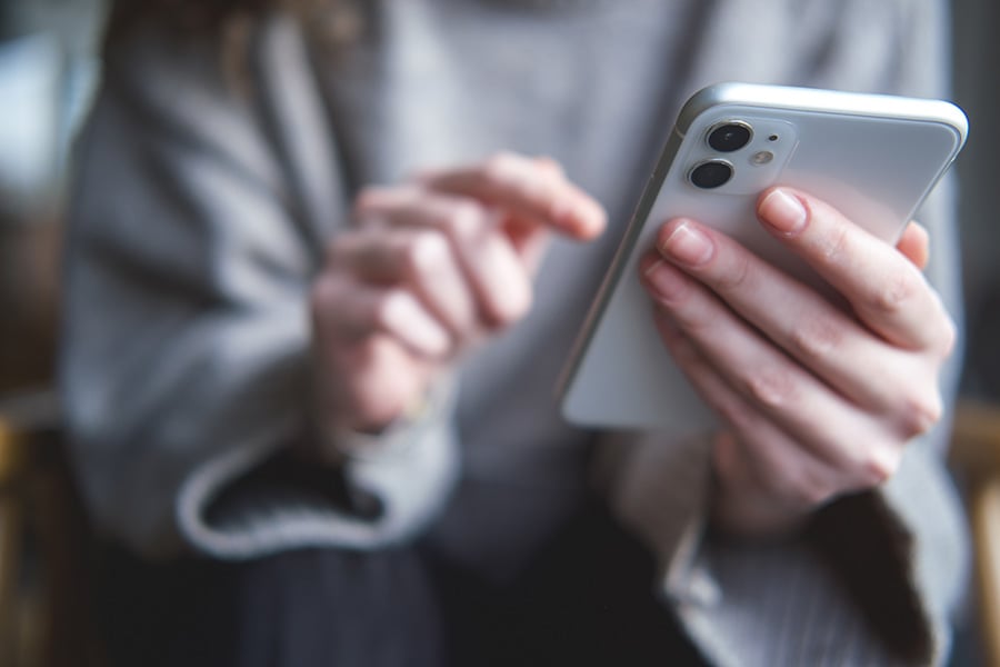 A close up of a young woman holding a mobile phone